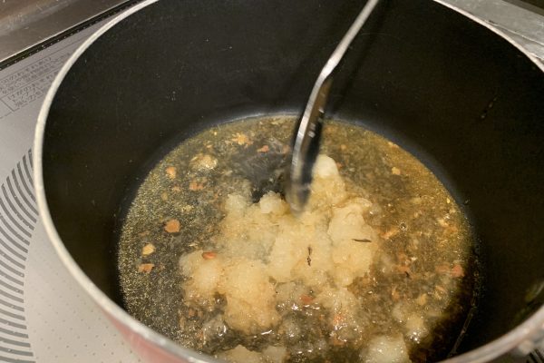大根おろしは鍋に入れ、「魚やの煮付 三陸真いわし」のトレーに残った汁をかけて混ぜながら温めます。