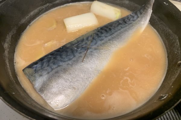 鯖のフィレを入れ、酒を鯖にかけるように入れます。